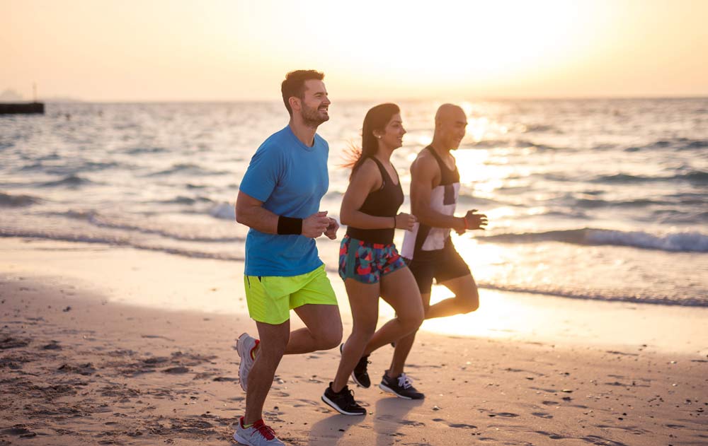 Drei Jogger am Strand