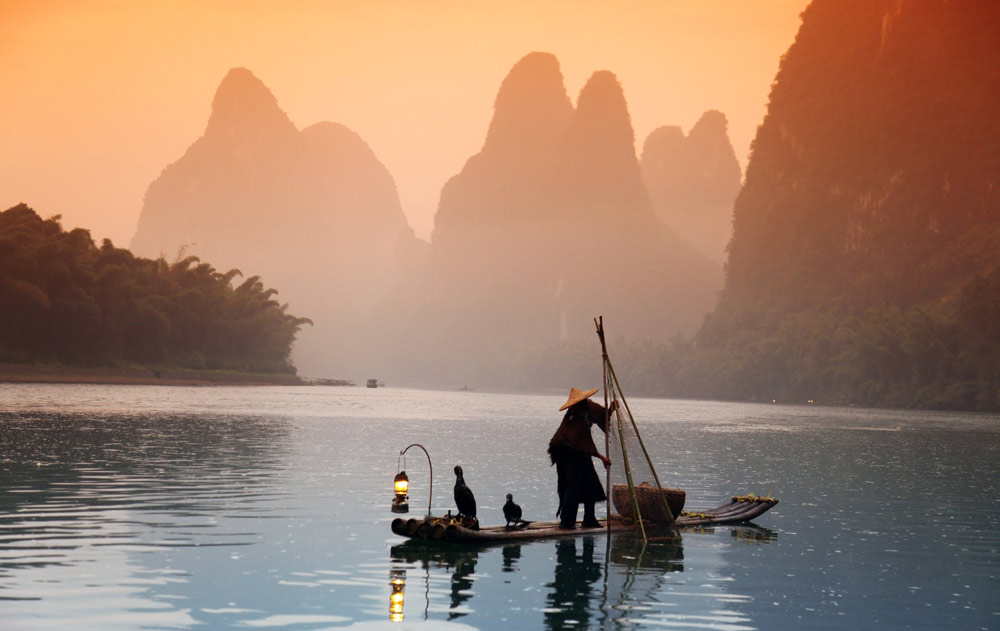 Mann auf einem kleinen Fischerboot in Asien