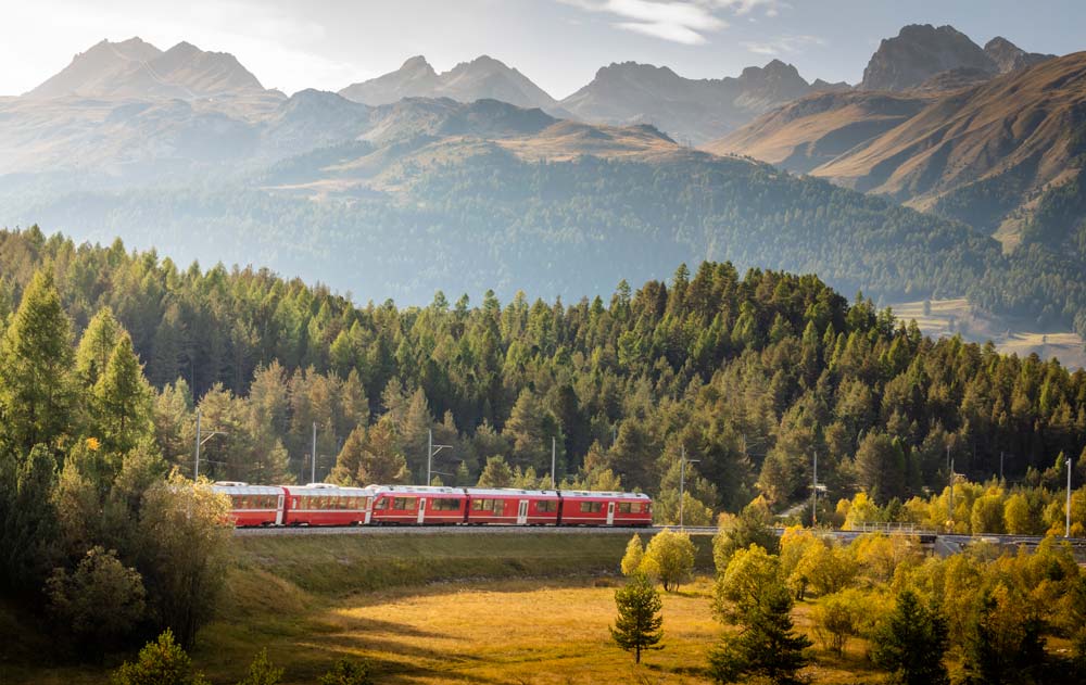 Zug fährt im Herbst durch das Engadin