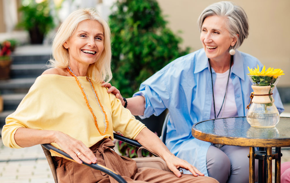 Zwei Seniorinnen sitzen an einem Tisch