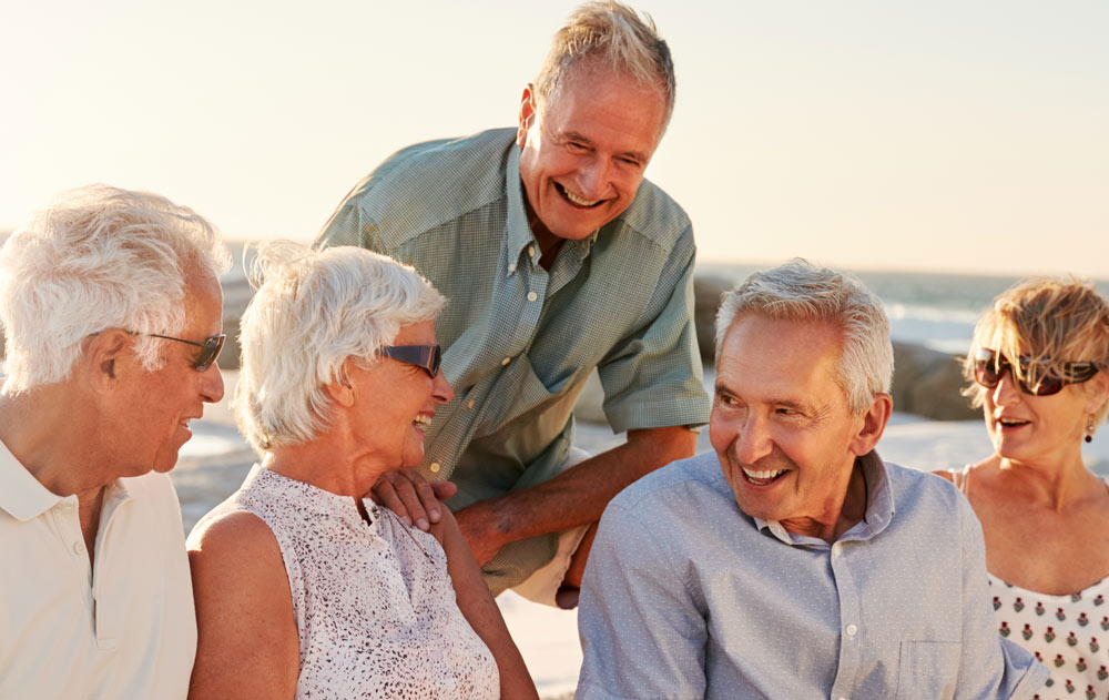 Eine lachende Gruppe Senioren am Meer
